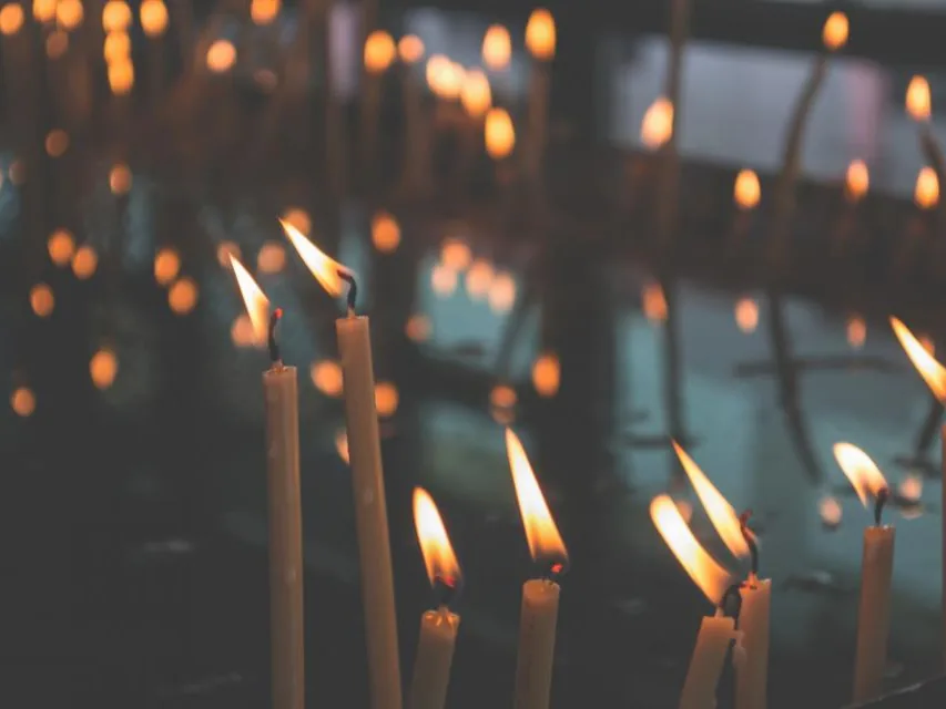 Bougies allumées dans la pénombre : support des rituels de purification et de protection