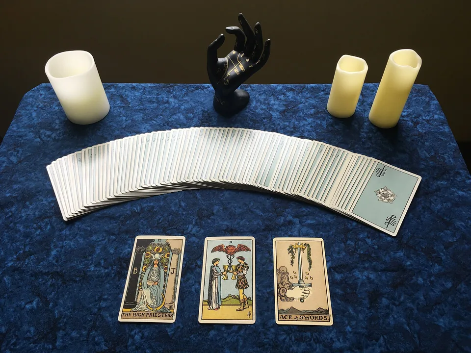 Tirage de cartes disposé sur une table avec bougies : support de lecture lors des consultations